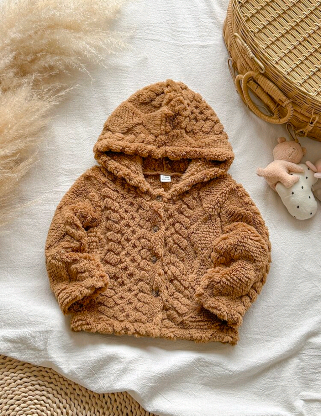 Baby caramel waffle-textured teddy fleece hooded button-front jacket, flat lay on white linen